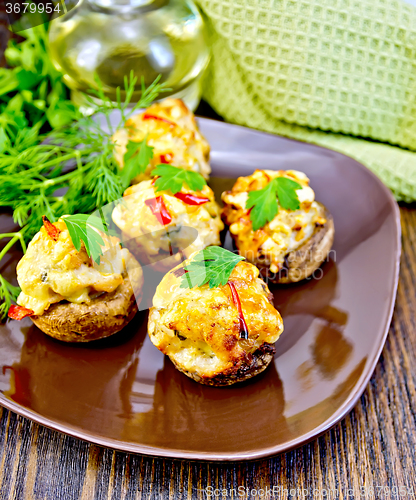 Image of Champignons stuffed meat in brown plate on board