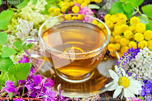 Image of Tea from flowers in glass cup on dark board