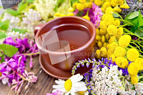 Image of Tea from wild flowers in clay cup on board