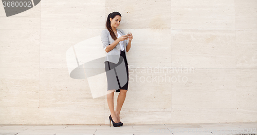 Image of Pretty young woman checking her mobile phone