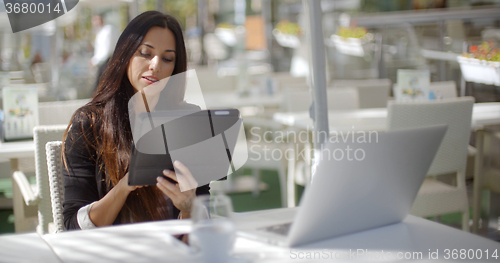 Image of Attractive businesswoman using a tablet pc