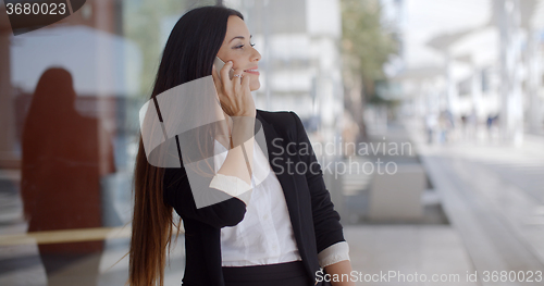 Image of Thoughtful gorgeous woman chatting on a mobile