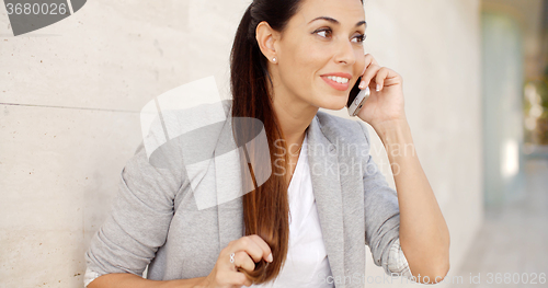 Image of Pretty woman smiling as she chats on a mobile