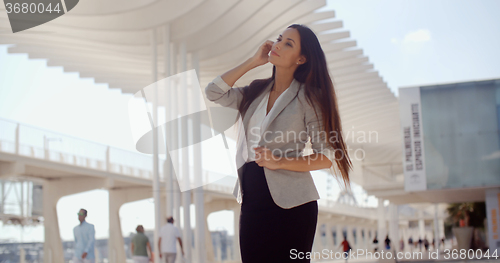 Image of Stylish woman with long hair standing on a mobile