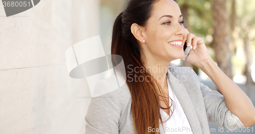 Image of Pretty woman smiling as she chats on a mobile