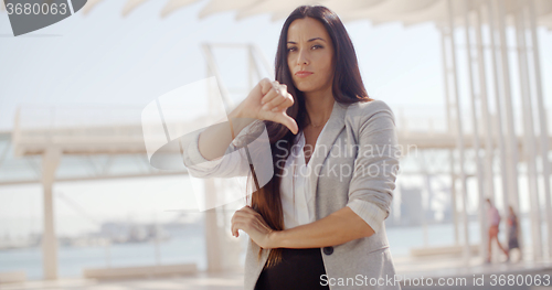 Image of Disappointed businesswoman giving a thumbs down