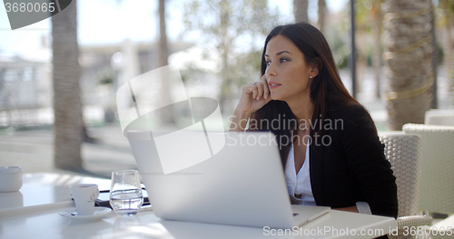 Image of Businesswoman sitting thinking at a restaurant