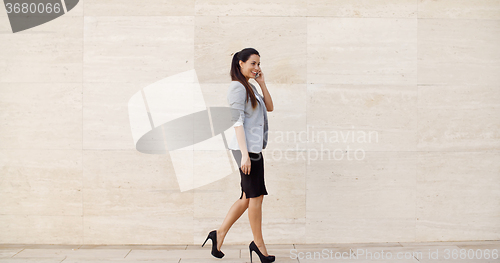 Image of Woman walking along a sidewalk