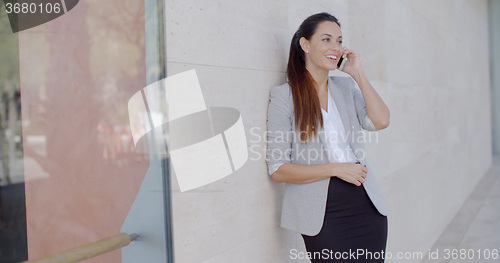 Image of Happy relaxed young woman chatting on her mobile