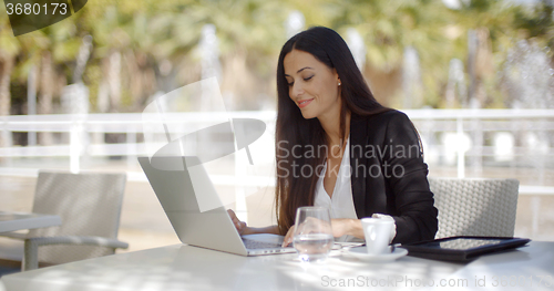 Image of Pretty stylish woman using her laptop