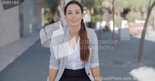 Image of Smiling confident businesswoman in town