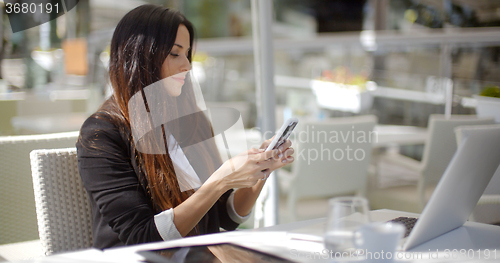 Image of Businesswoman checking her mobile phone