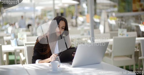 Image of Businesswoman making a call at a restaurant
