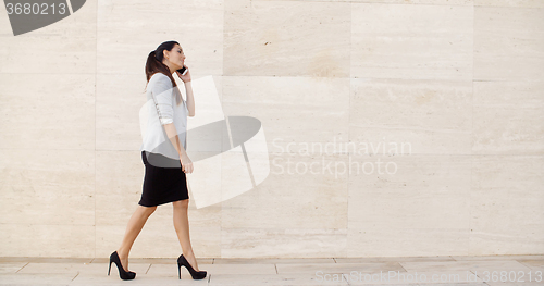 Image of Woman walking along a sidewalk