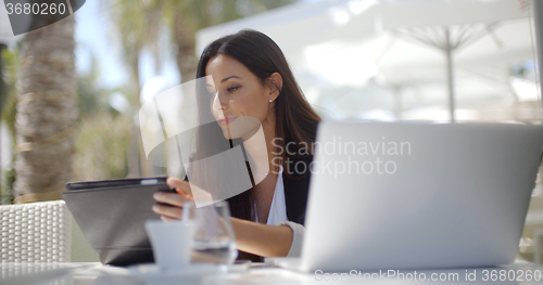 Image of Businesswoman making a call at a restaurant