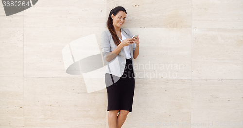 Image of Pretty young woman checking her mobile phone
