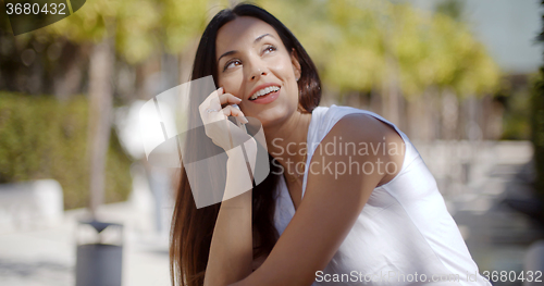 Image of Vivacious young woman chatting on her mobile