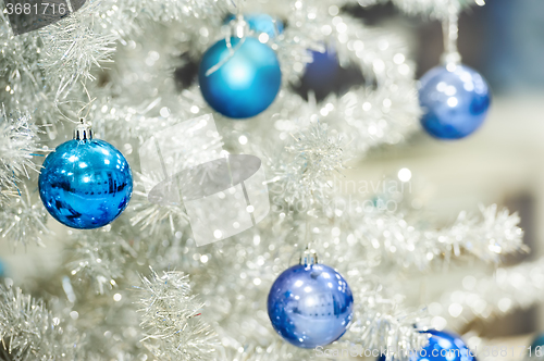 Image of Blue baubles on silver artificial christmas tree