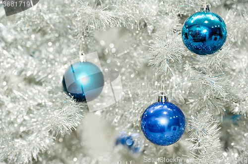 Image of Blue baubles on silver artificial christmas tree