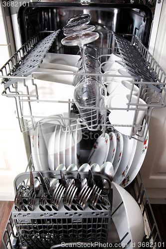 Image of Open dishwasher with clean utensils