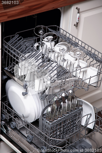 Image of Open dishwasher with clean utensils