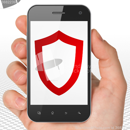 Image of Safety concept: Hand Holding Smartphone with Contoured Shield on display