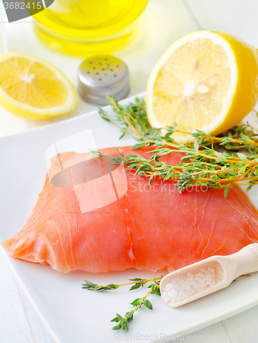 Image of Raw salmon on the white plate with thyme and salt
