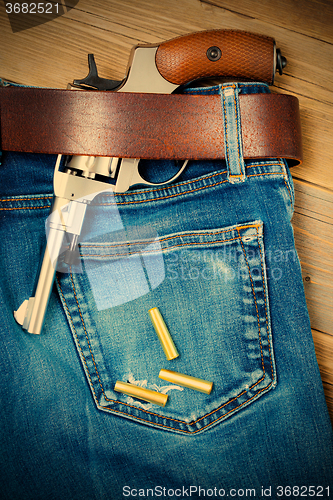 Image of revolver under a leather belt