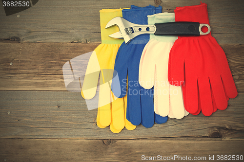 Image of varicolored workers gloves and wrench