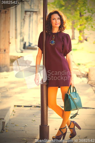 Image of smiling middle-aged woman in a burgundy dress