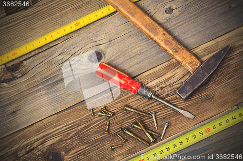 Image of Vintage hammer, screwdriver, screws and measuring tape