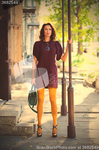 Image of beautiful middle-aged woman in a burgundy dress