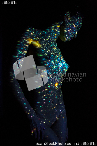 Image of The  body of woman with color pattern in the beam projector