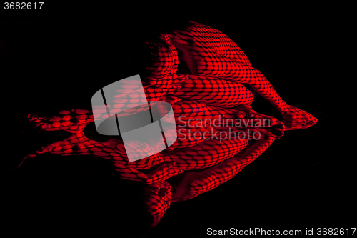 Image of The  body of woman with red pattern and its reflection