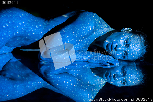 Image of The  body of woman with blue pattern and its reflection