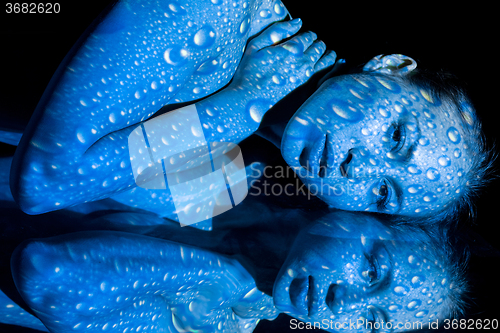 Image of The  body of woman with blue pattern and its reflection