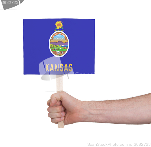 Image of Hand holding small card - Flag of Kansas