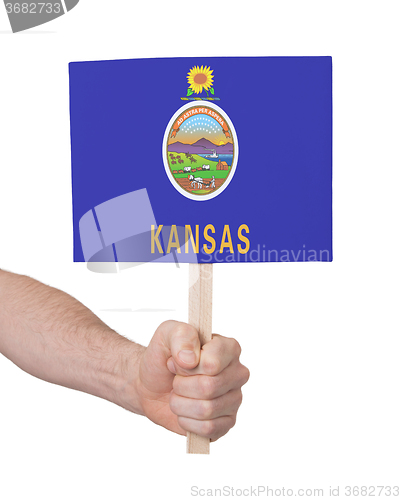 Image of Hand holding small card - Flag of Kansas