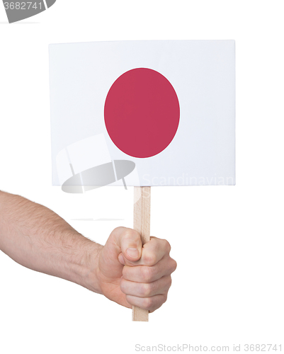 Image of Hand holding small card - Flag of Japan