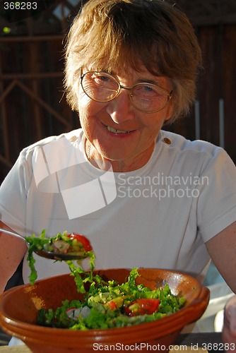 Image of Happy eating senior woman