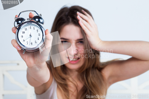 Image of The young girl in bed with  clock service