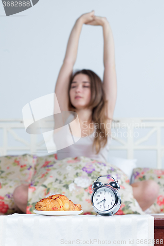 Image of The young girl in bed with  clock service