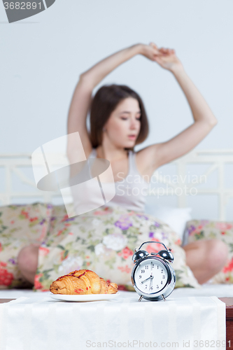 Image of The young girl in bed with  clock service