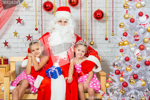 Image of Santa Claus hugging two girls sisters