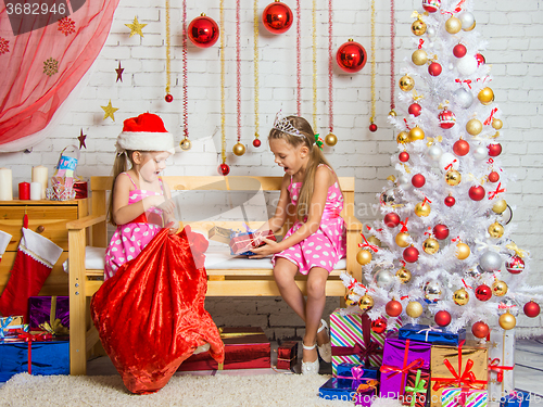 Image of Two girls pulled out a bag of Christmas gifts Santa Claus