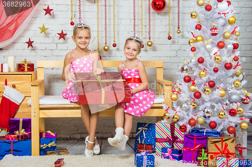 Image of Happy girl who gave a great gift sitting on a bench in a Christmas setting