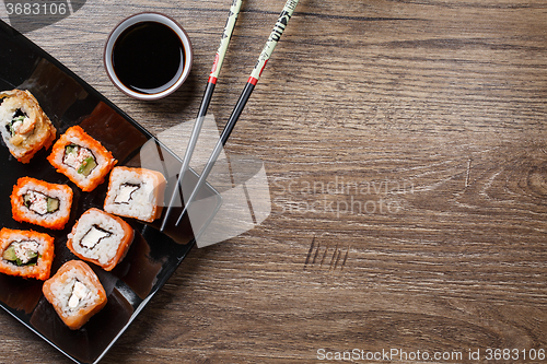 Image of Sushi roll with chopsticks