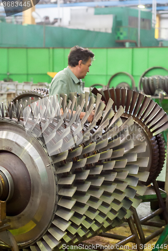 Image of Mechanic works with parts of aviation engine