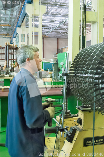 Image of Mechanic works with part of aviation engine