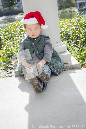 Image of Melancholy Mixed Race Boy Wearing Christmas Santa Hat